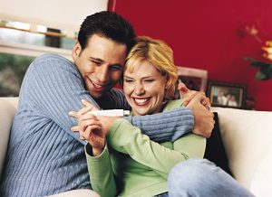 Couple Embracing After Looking at Pregnancy Test